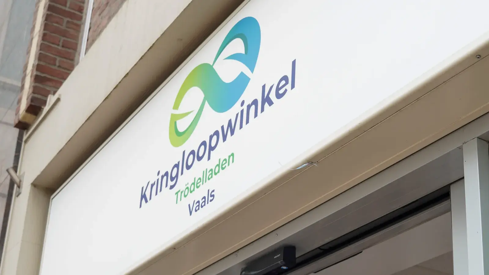 Het uithangbord van Kringloopwinkel Vaals boven de open winkeldeur