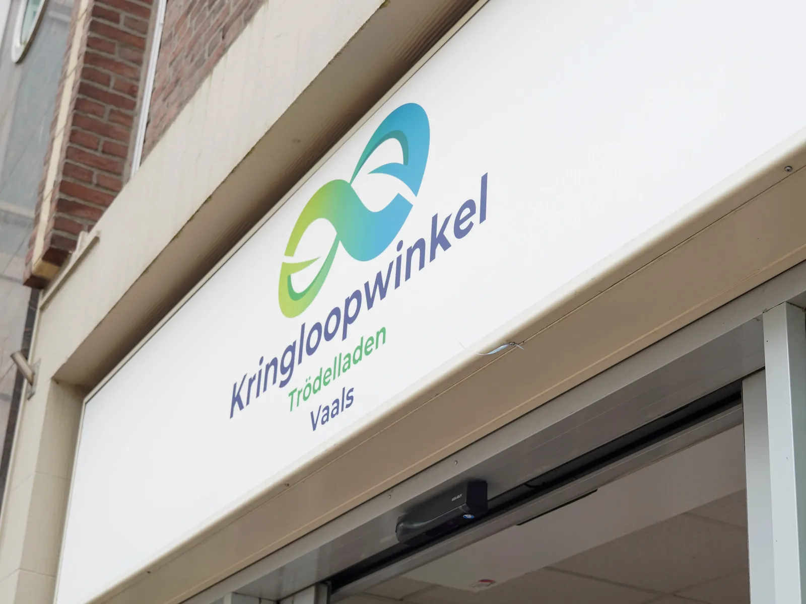 Het uithangbord van Kringloopwinkel Vaals boven de open winkeldeur